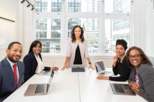 Équipe multiculturelle collaborant dans une salle de réunion avec des ordinateurs portables, mettant en valeur le travail d'équipe et la diversité.