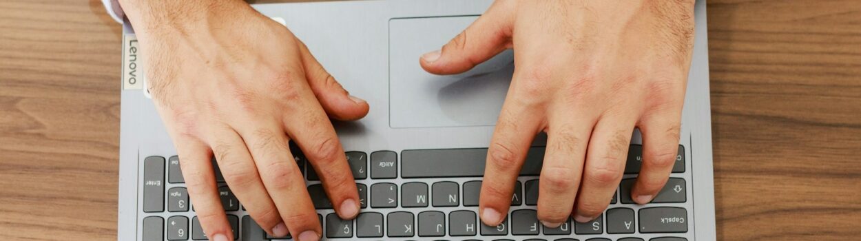 Une personne tape sur un ordinateur portable à un bureau.